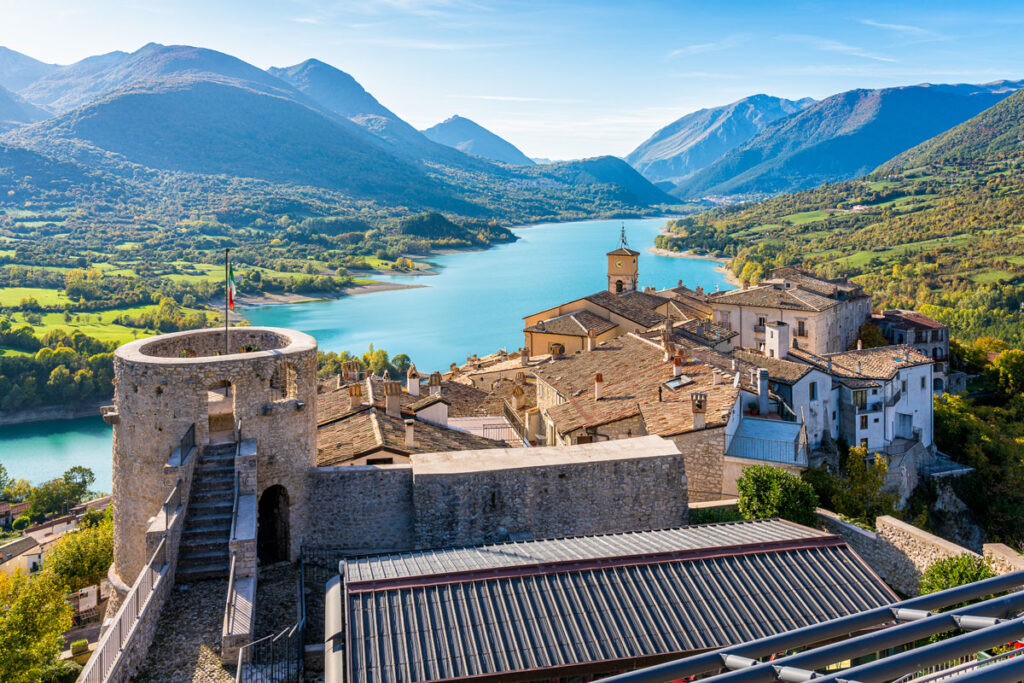 Vista panoramica del borgo di Barrea, circondato dalla natura incontaminata dell’Abruzzo, con il lago e le montagne che offrono un’esperienza unica di natura e relax.