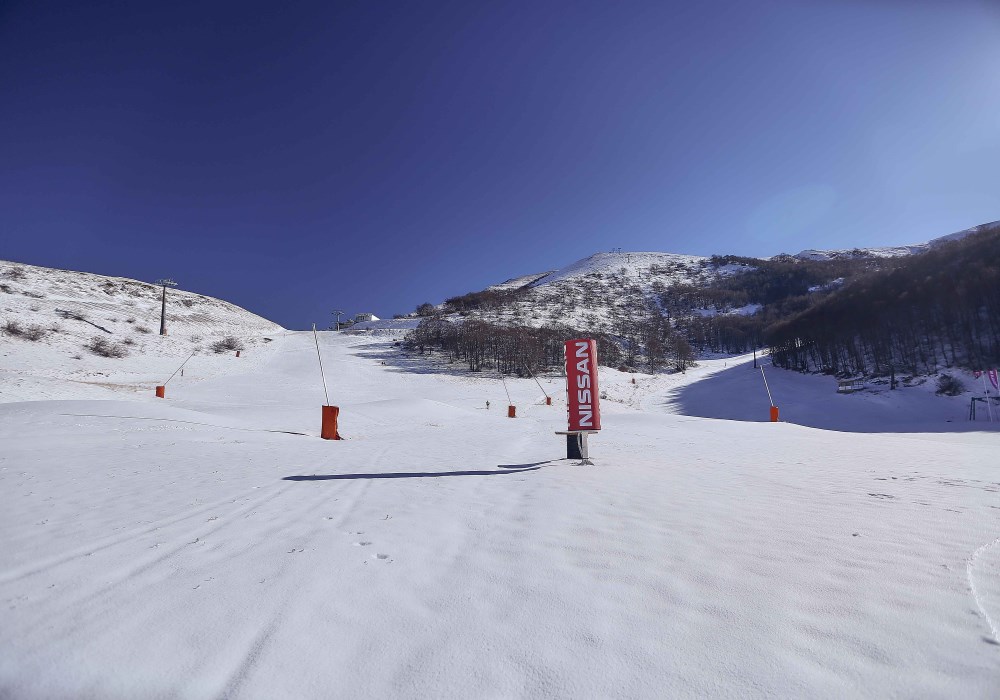 Pista da sci perfettamente innevata nella stazione sciistica di Campo Felice, con un cielo limpido e paesaggi montani suggestivi dell'Abruzzo.